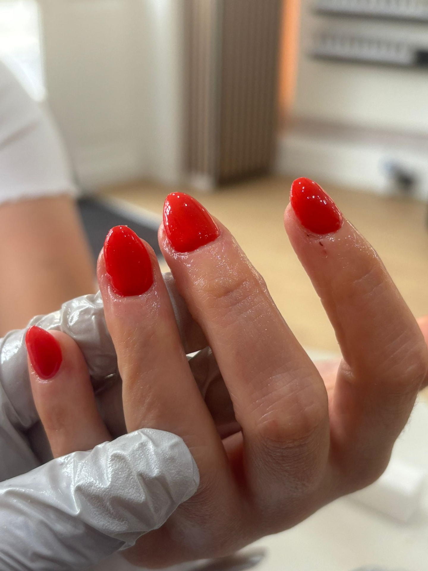Glossy red almond-shaped gel nails at Beauty on View