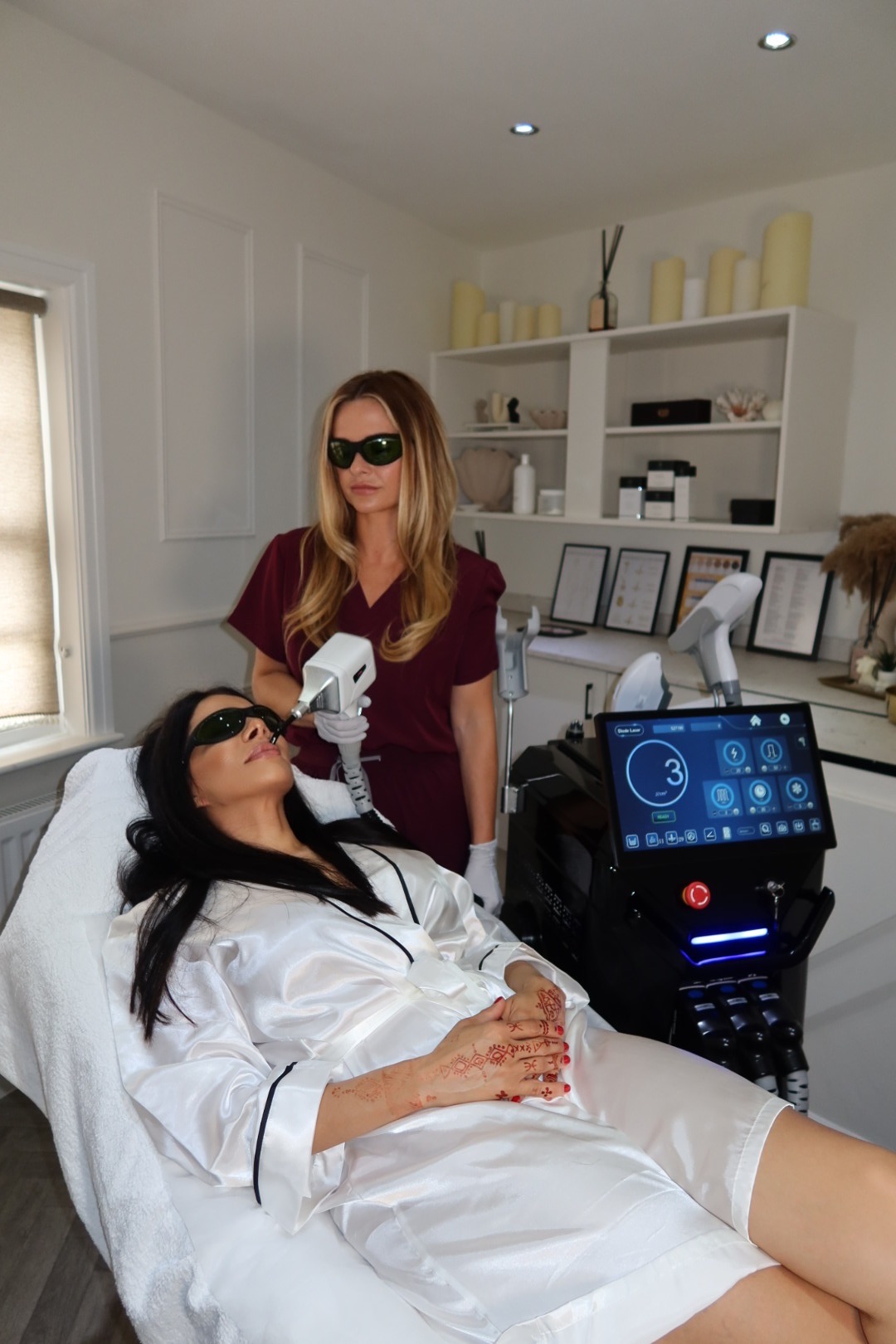 Practitioner performing laser hair removal on a client's face
